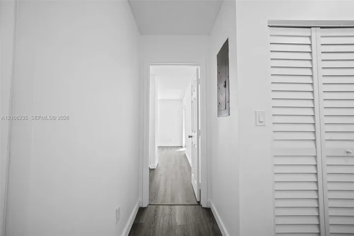 Wood-finish flooring, white walls, and bi-fold louvered closet doors