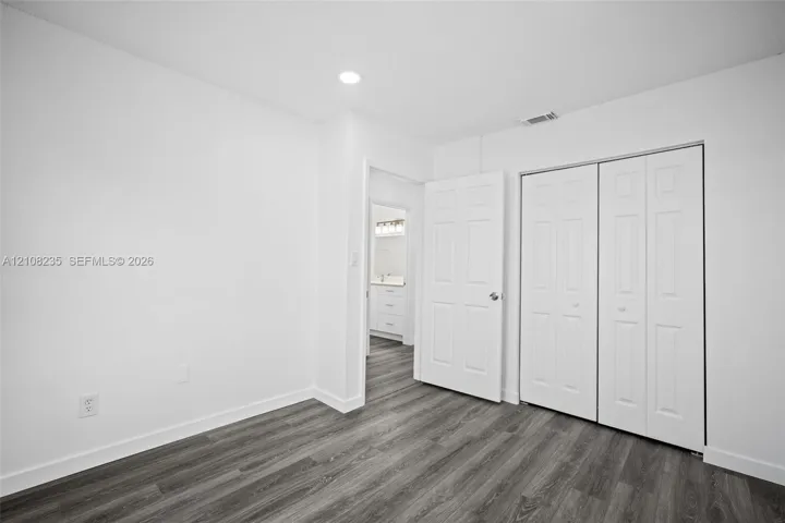 Wood-finish flooring, recessed lighting, and white bi-fold closet doors