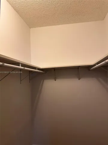 Storage area featuring wrap-around shelving and mounted clothing rods