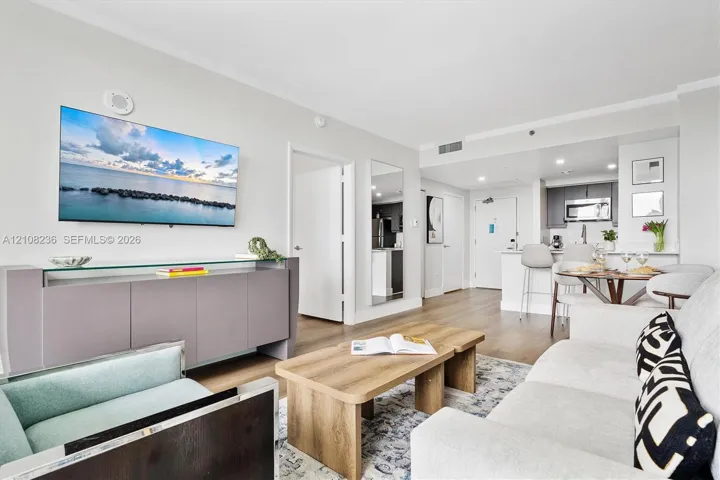 Open-concept floor plan featuring wood-finish flooring, recessed lighting, and a breakfast bar