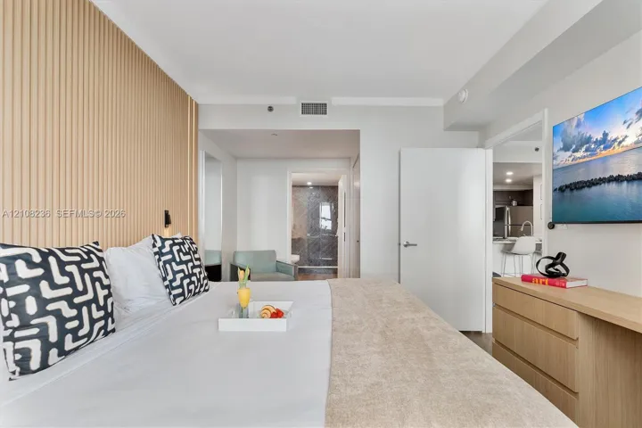 Interior space featuring a vertical slat wood-finish accent wall, neutral wall palette, and built-in wood-finish cabinetry