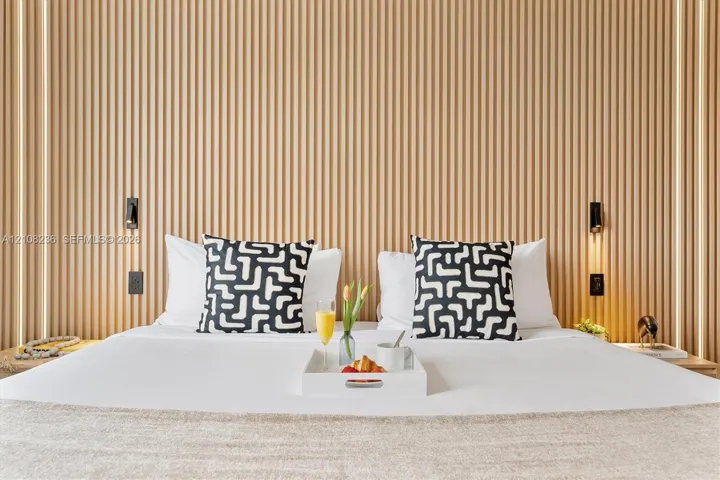 Vertical wood slat accent wall featuring integrated recessed LED lighting strips and wall-mounted reading lights