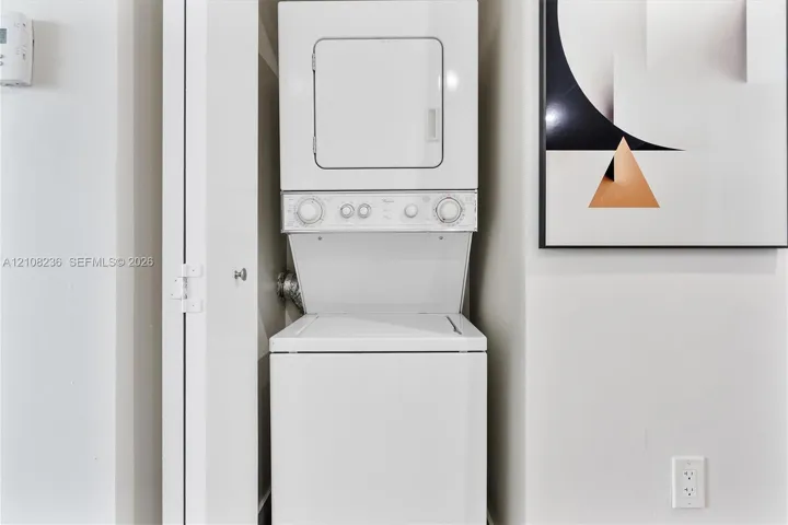 Stacked white laundry unit housed within a built-in closet
