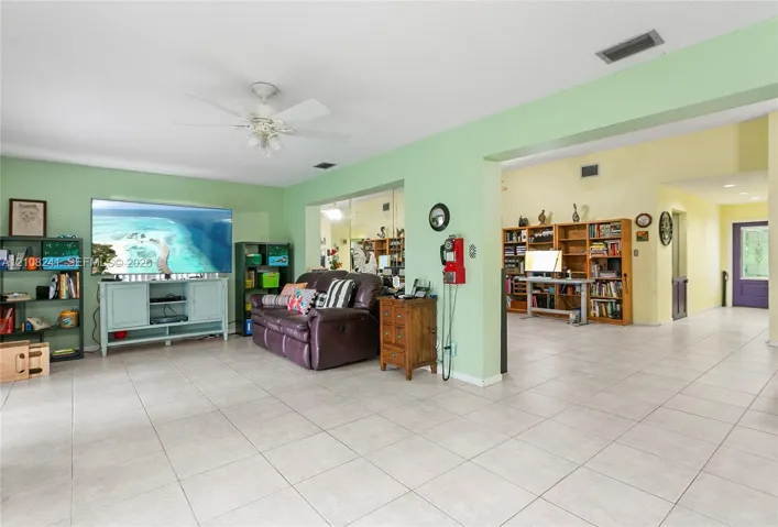 Spacious interior featuring ceramic tile flooring, built-in wooden shelving, and a ceiling fan with integrated lighting