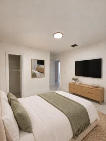 Neutral interior featuring polished stone-finish flooring, recessed lighting, and a square wall-mounted mirror with a wood-tone frame