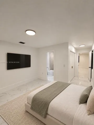 Neutral-toned interior featuring large-format stone-finish tile flooring, flush-mount circular lighting, and double-door closet storage