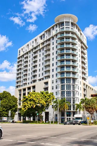 High-rise exterior featuring curved glass balconies, concrete facade, and a tiered architectural roofline
