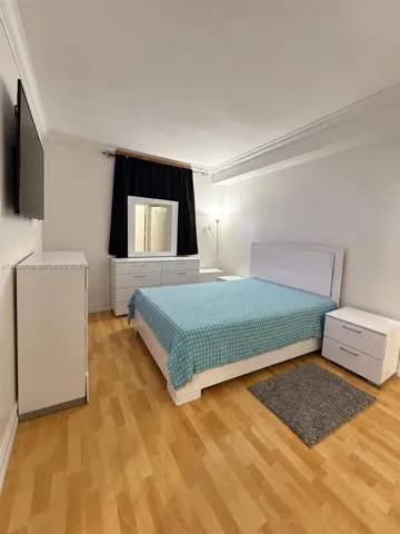 Wood-finish flooring, crown molding, and neutral wall tones