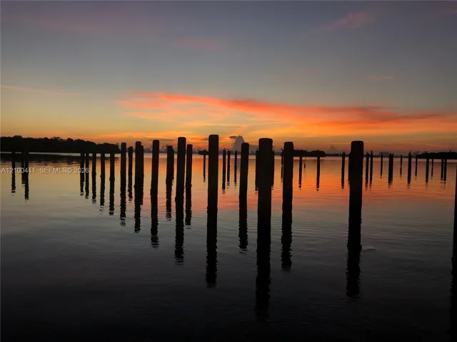 Waterfront bulkhead pilings set against a colorful sunset backdrop