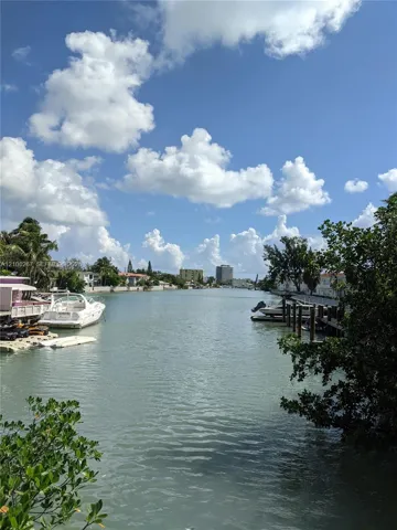 Waterfront property featuring a private wooden dock, direct canal access, and mature coastal vegetation