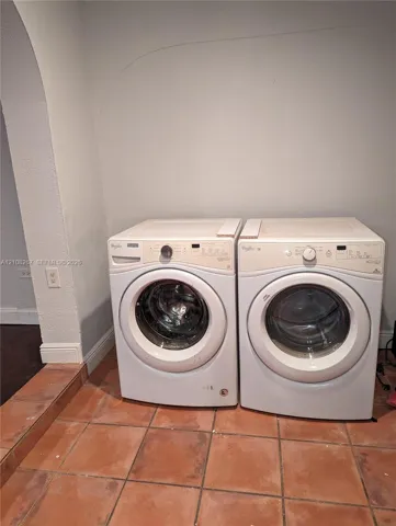 Laundry area featuring ceramic tile flooring and an arched architectural​​‌​​​​‌​​‌‌​‌‌​​​‌‌​‌​‌​‌​​​‌​​ opening