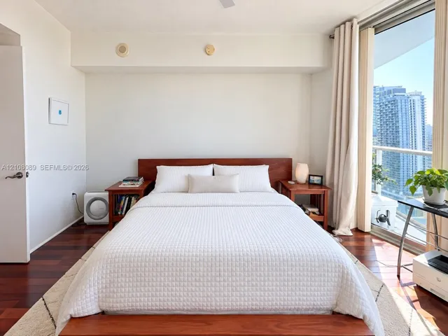 Wood-finish flooring, floor-to-ceiling glass wall, and balcony access