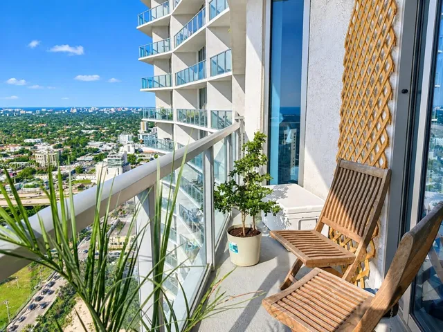 High-rise balcony featuring glass railings and panoramic urban scenery