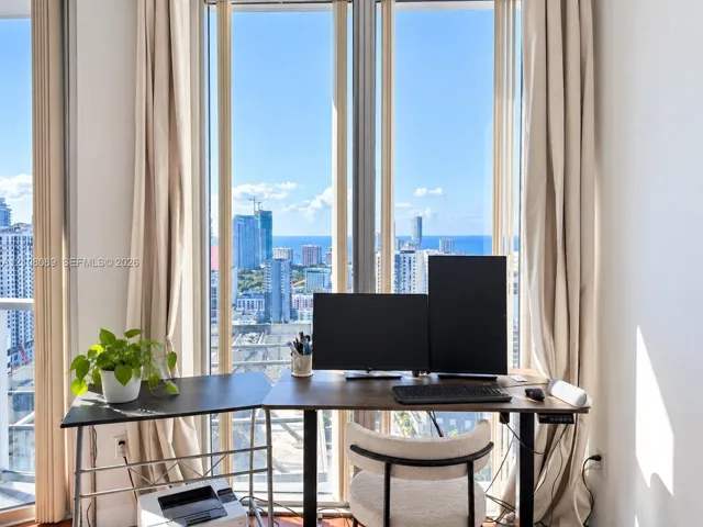 Floor-to-ceiling windows featuring urban and ocean scenery