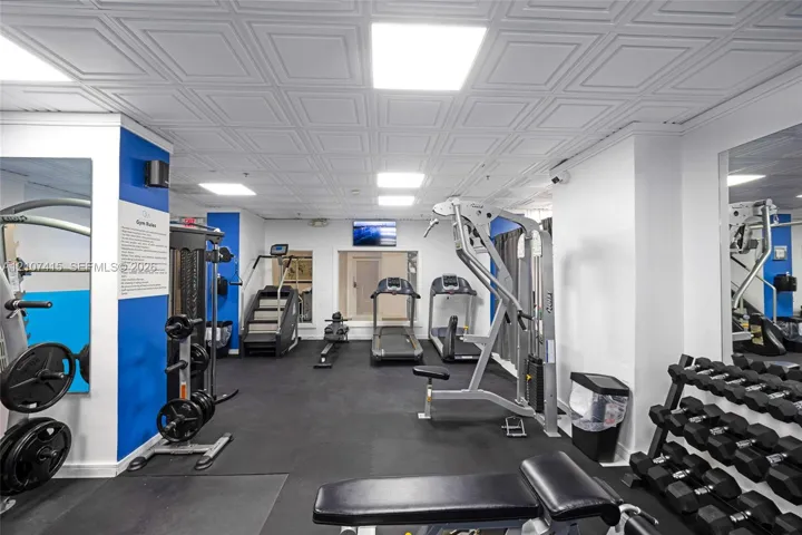 Coiffured ceiling tiles, integrated recessed lighting, wall-mounted mirrors, and resilient rubberized flooring