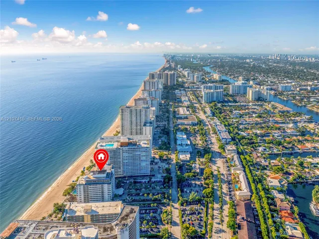 Aerial perspective of coastal high-rise development featuring direct oceanfront positioning and immediate proximity to the shoreline