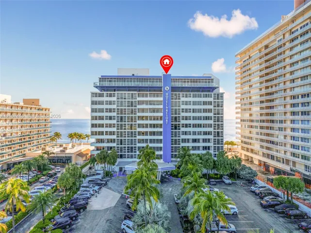 High-rise residential exterior featuring expansive glass windows, integrated balconies, and mature tropical landscaping