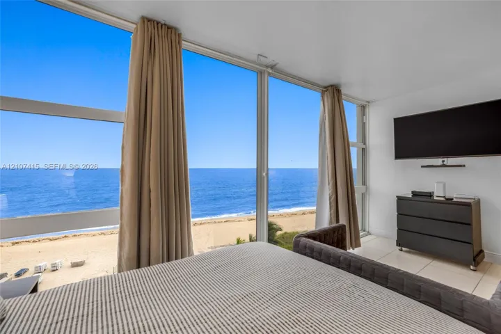 Floor-to-ceiling windows, large-format tile flooring, and coastal scenery