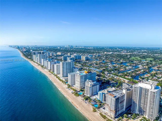 Coastal aerial perspective featuring direct oceanfront access, sandy beaches, and high-rise structures