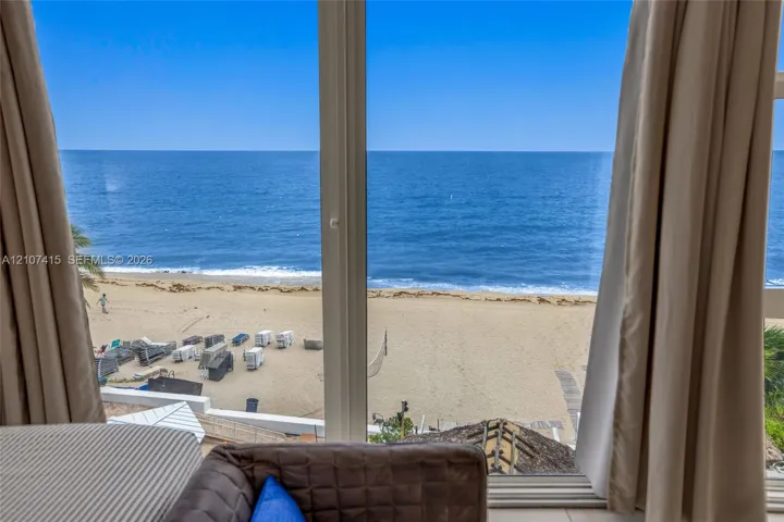 Floor-to-ceiling windows with expansive ocean, beach, and shoreline scenery