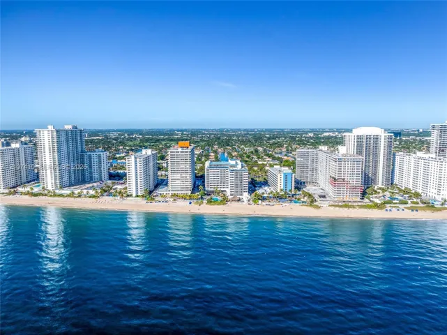 Coastal cityscape featuring high-rise architecture, direct shoreline access, and expansive ocean frontage