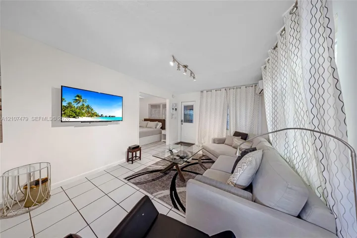 Bright living area featuring ceramic tile flooring, neutral wall tones, and track lighting