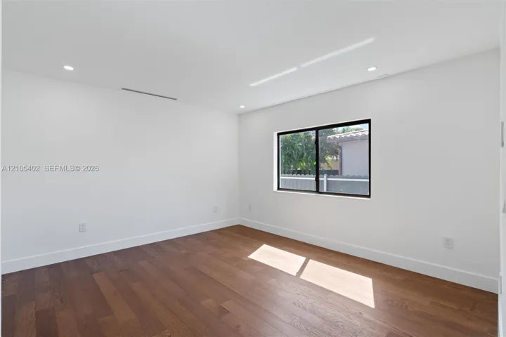 Interior space featuring wood-finish flooring, recessed lighting, and a single-pane window with a black frame