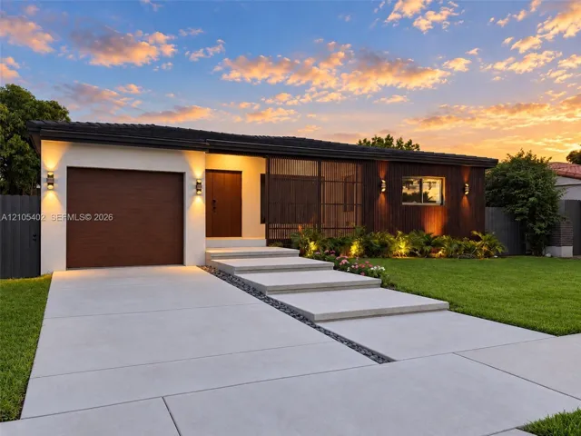 Modern exterior featuring a combination of stucco and wood-finish cladding, single-car garage, integrated screen paneling, and concrete slab walkway with stone accent border