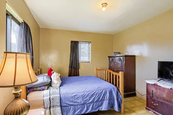 Room featuring wood-finish flooring, dual windows with natural light, and an overhead flush-mount light fixture