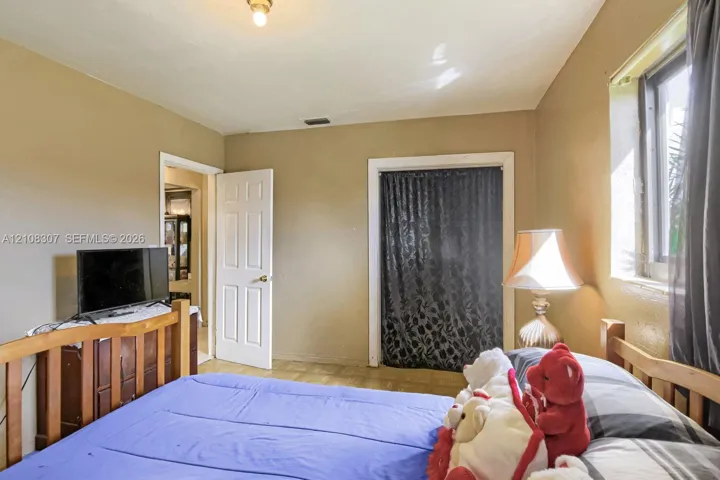 Room featuring a flush-mount ceiling light, single-panel interior door, and window with casing