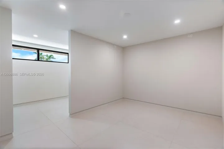 Neutral-toned interior featuring large-format tile flooring, recessed ceiling lighting, and a horizontal clerestory window