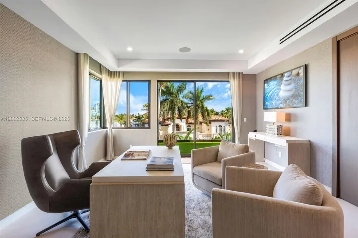 Room featuring textured wallpaper, recessed lighting, crown molding, built-in recessed wall shelving, and floor-to-ceiling glass doors with outdoor scenery