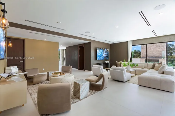 Large living area featuring large-format tile flooring, recessed ceiling lighting, linear HVAC diffusers, and sliding glass wall panels
