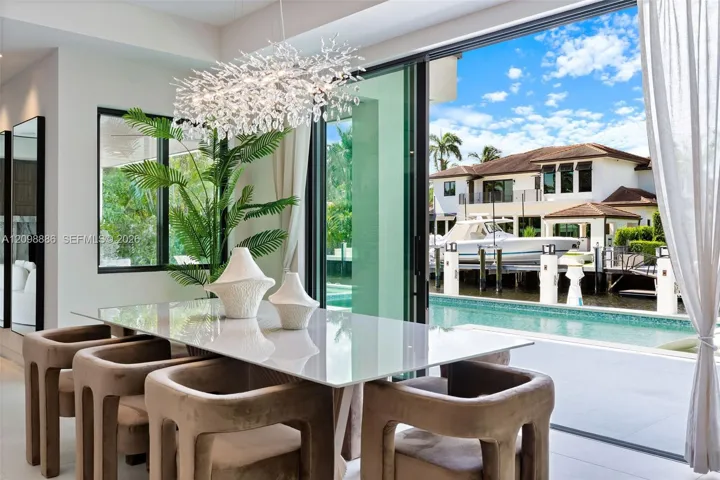 Multi-panel sliding glass doors, contemporary crystal chandelier, built-in swimming pool, deep-water dockage, and large-format tile flooring