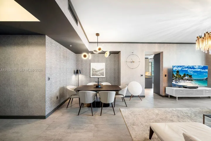 Textured wall coverings, large-format tile flooring, recessed ceiling lighting, and multi-arm geometric chandeliers