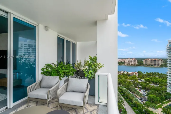 Covered balcony featuring floor-to-ceiling glass doors, a glass panel railing, and stone tile flooring