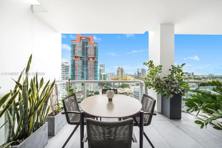 Covered balcony featuring large-format stone-style flooring and glass-panel railings