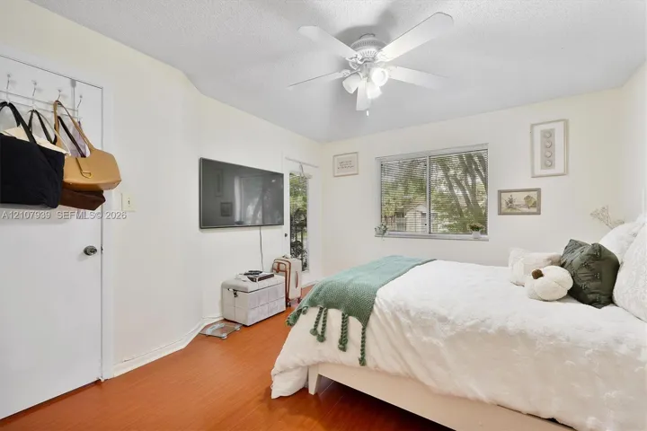 Wood-finish flooring, ceiling fan with integrated light fixture, and large sliding window