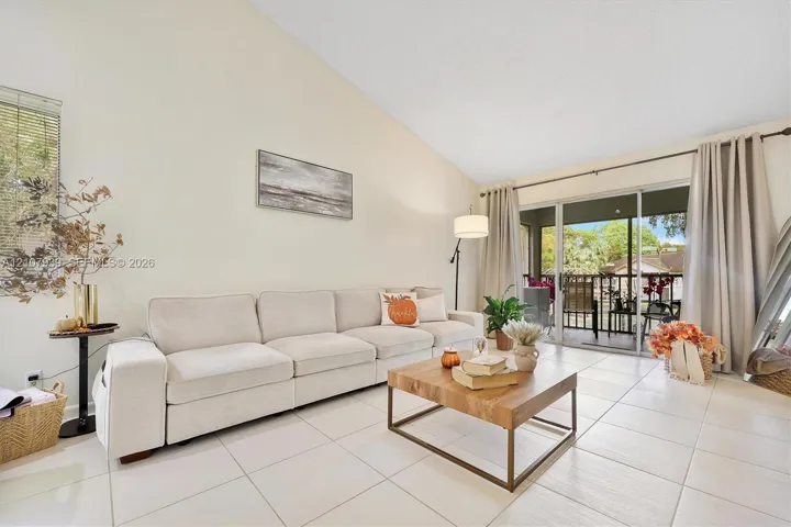 Vaulted ceilings, large-format tile flooring, and glass sliding doors providing external access