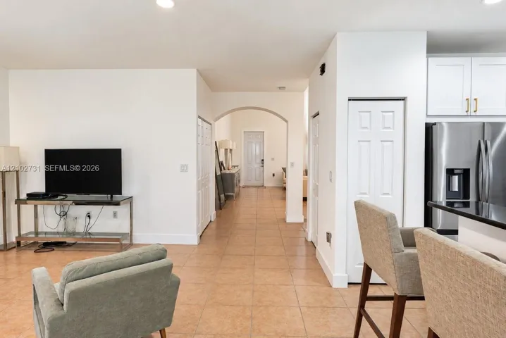 Ceramic tile flooring, arched entryways, recessed ceiling lighting, and stainless steel kitchen appliances