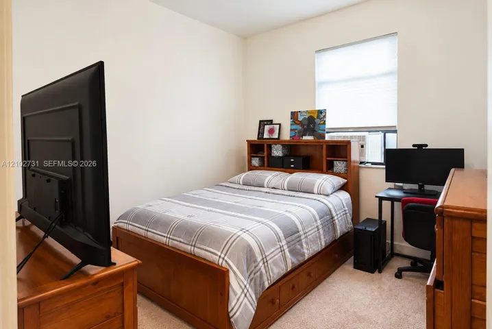 Neutral-toned interior featuring wall-to-wall carpeting and a window equipped with a retractable blind