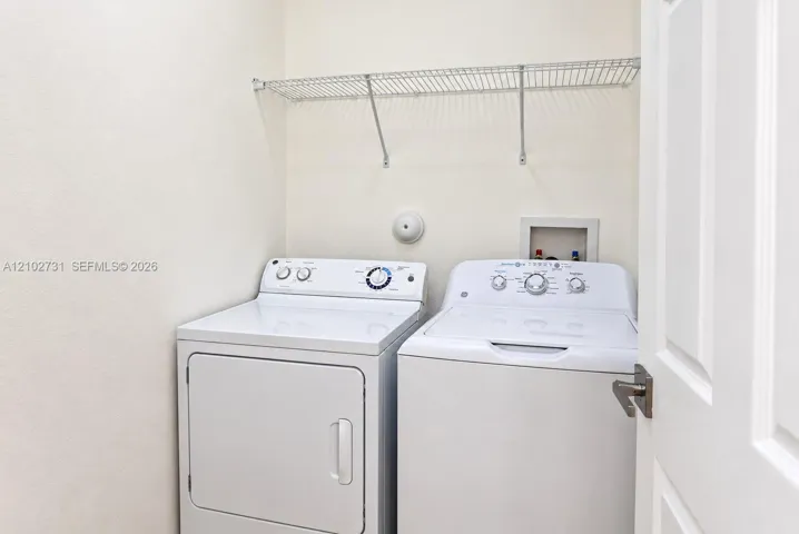 Laundry space featuring a built-in wire shelving unit and hookups for a washer and dryer