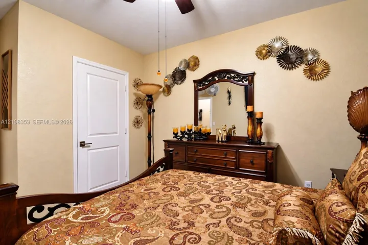 Room featuring a two-panel interior door with brushed metallic hardware and a ceiling-mounted light fixture with a fan