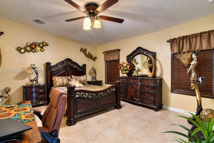 Neutral-toned interior featuring tile flooring, a multi-blade ceiling fan with integrated light fixture, and horizontal window blinds