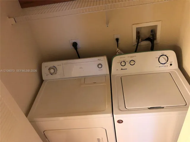 Laundry area featuring a built-in wire shelf, dedicated appliance hookups, and a recessed water supply box