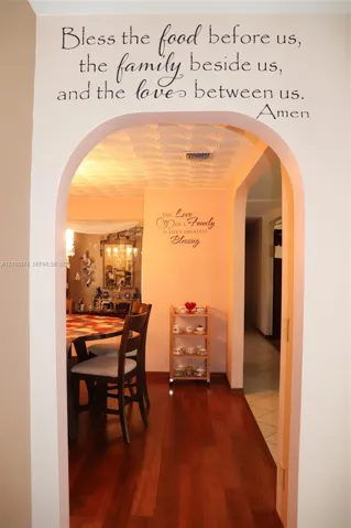 Architectural arched doorway featuring wood-finish flooring and textured ceiling detail