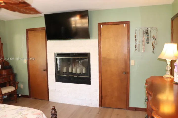 White painted brick fireplace surround, inset firebox, and wood-finish flooring