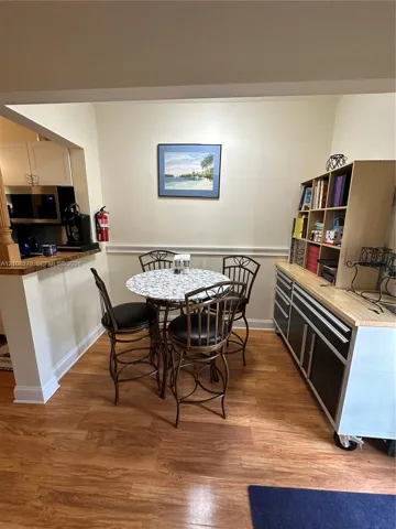 Wood-finish flooring, half-wall partition with a wood-surface counter, and wall-mounted chair rail molding