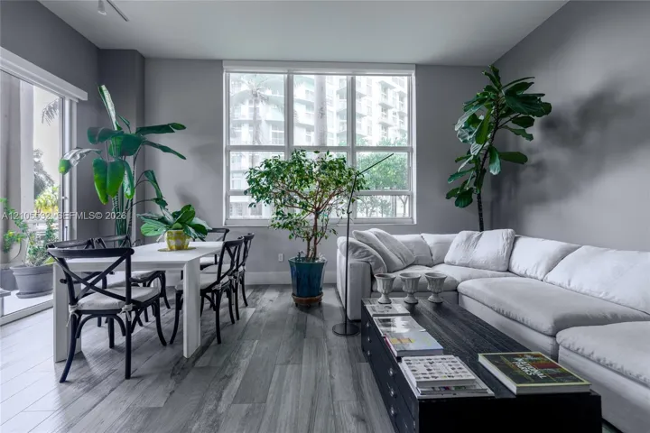 Living area featuring wood-finish flooring, floor-to-ceiling windows, and access to an exterior terrace