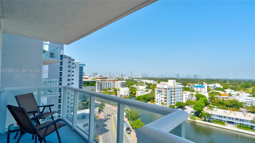 Private balcony featuring a glass panel railing and elevated cityscape scenery